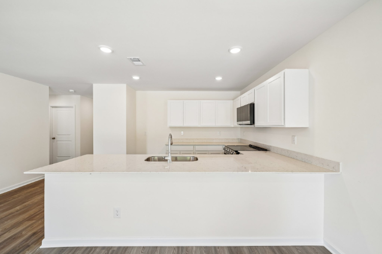 A kitchen with white cabinets.