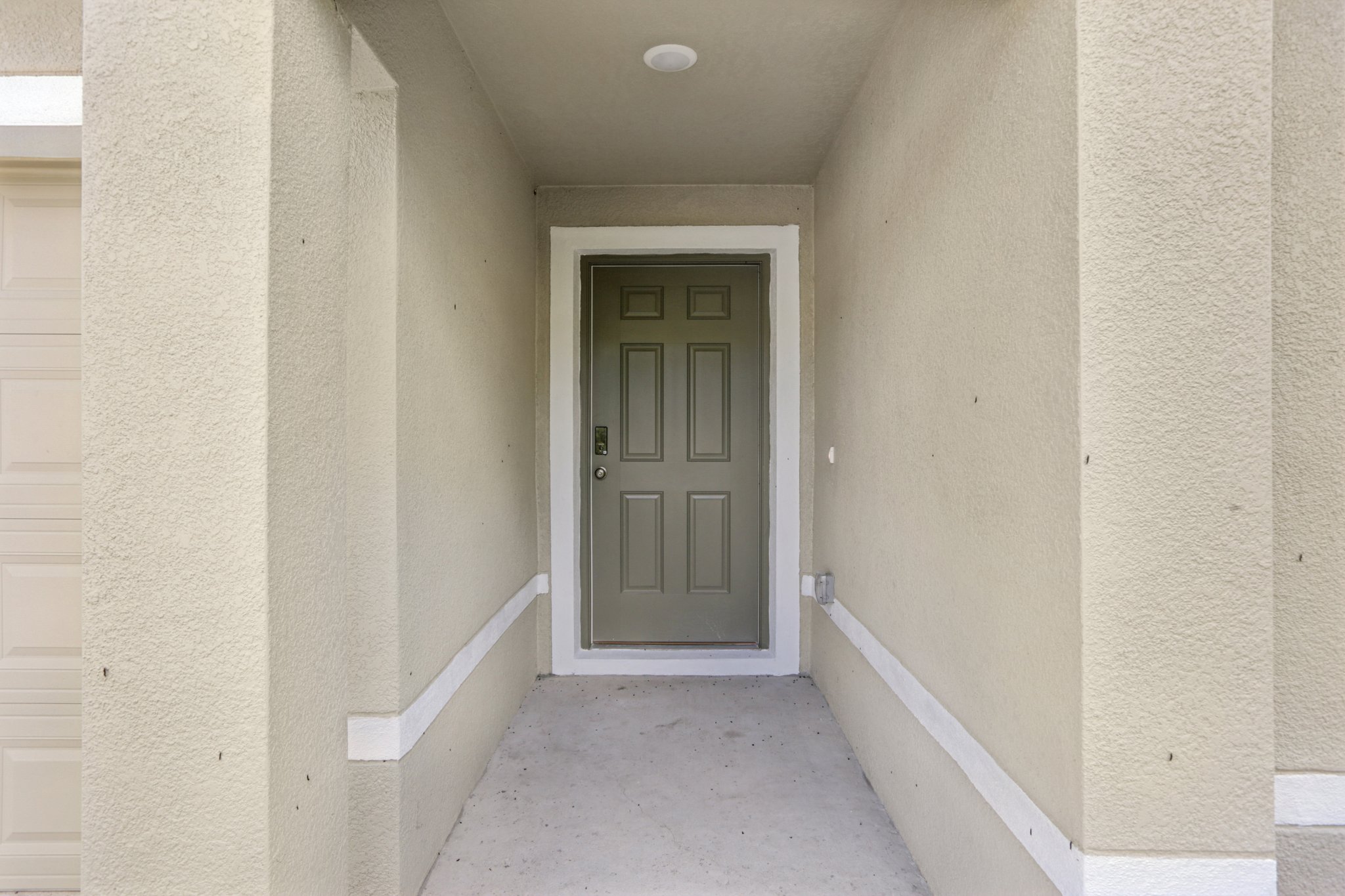 A white hallway with a door.