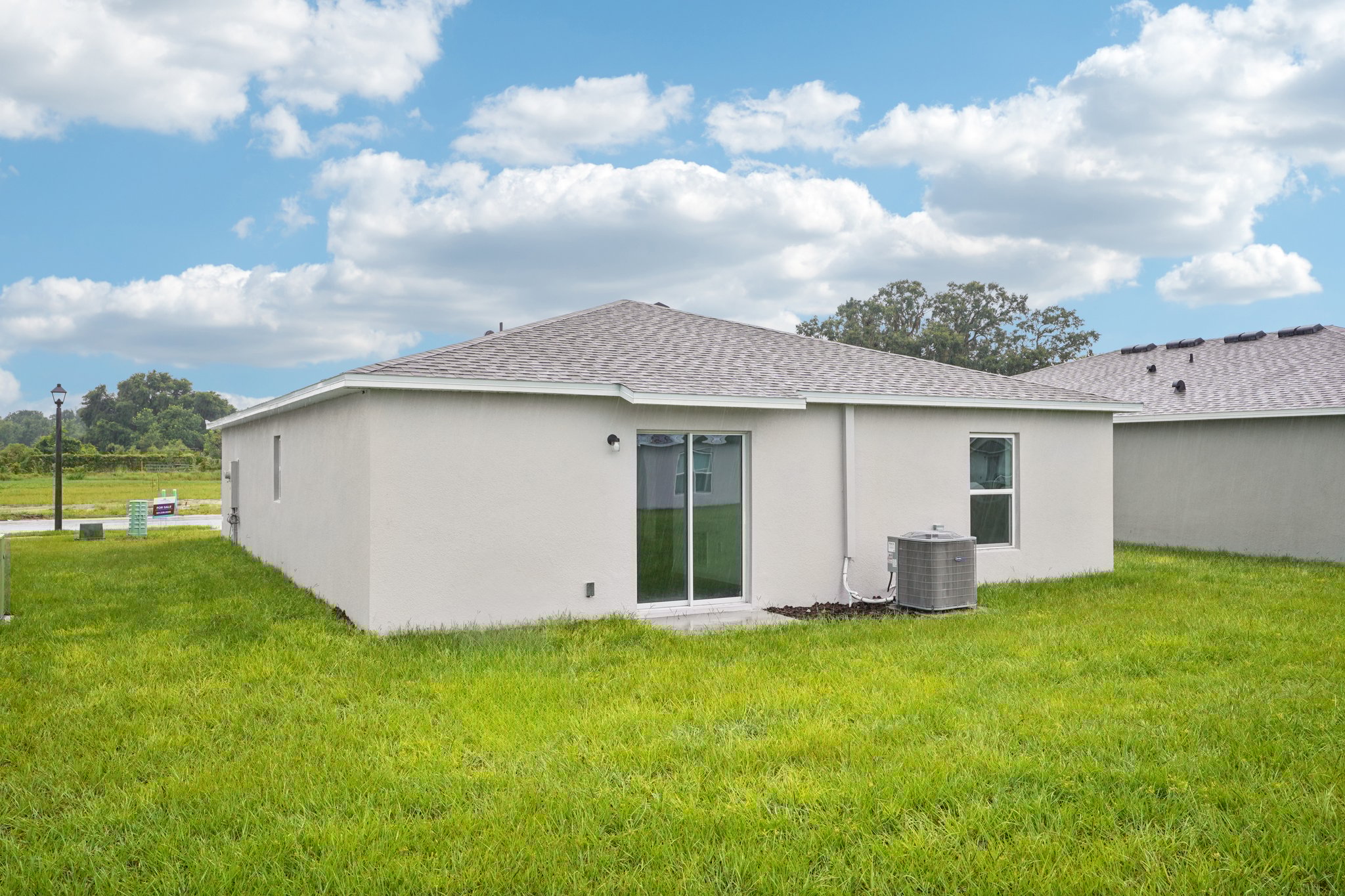 A white house with a green lawn.