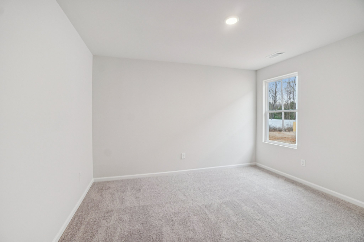 A room with a carpet and a window.