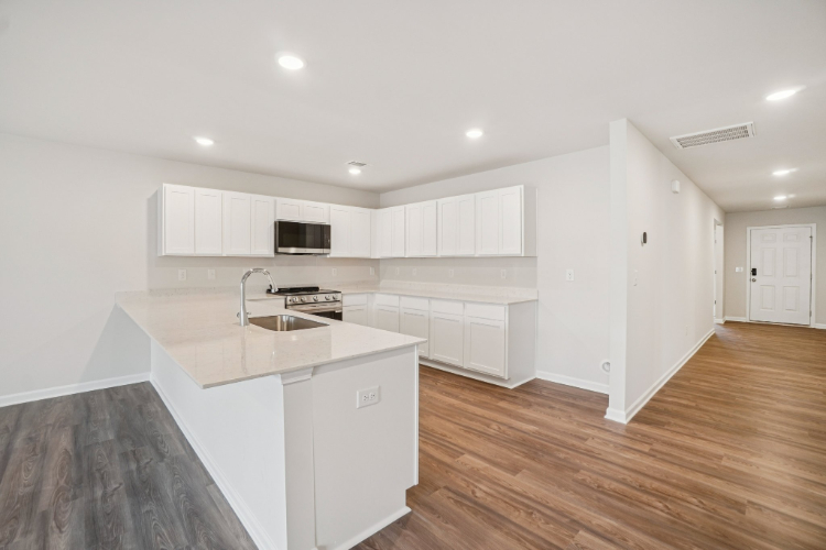 A kitchen with white cabinets.