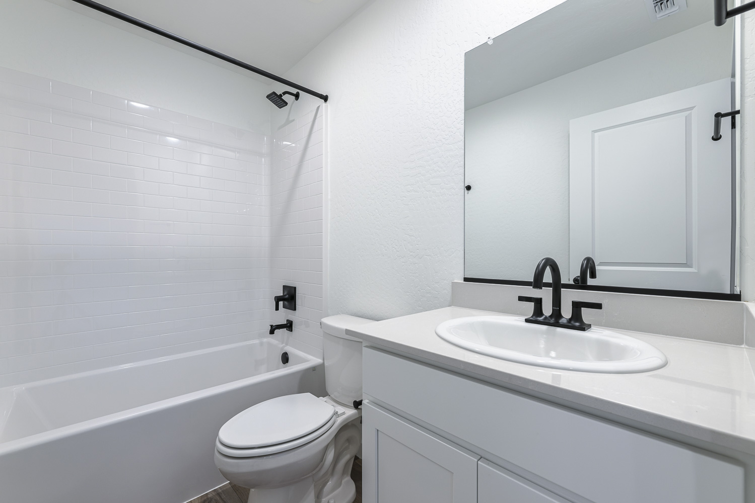 A bathroom with a sink toilet and bathtub.