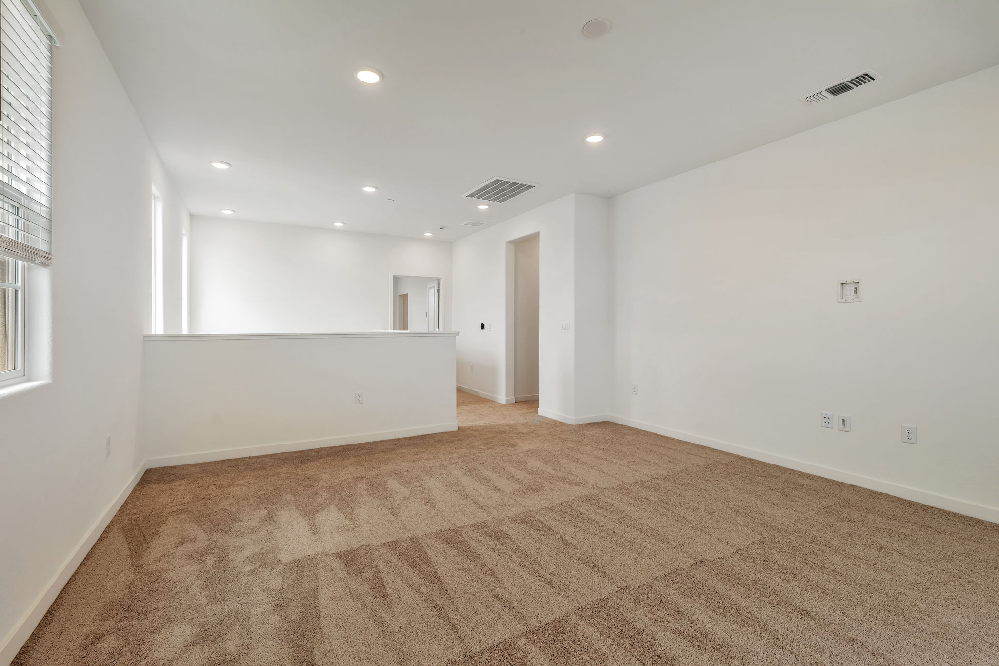 A room with a carpet and a window.